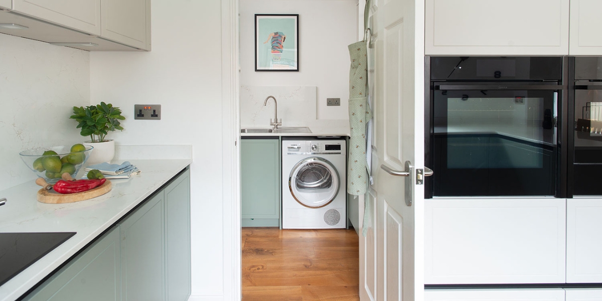 An image looking through a kitchen door into a stylish utility room.