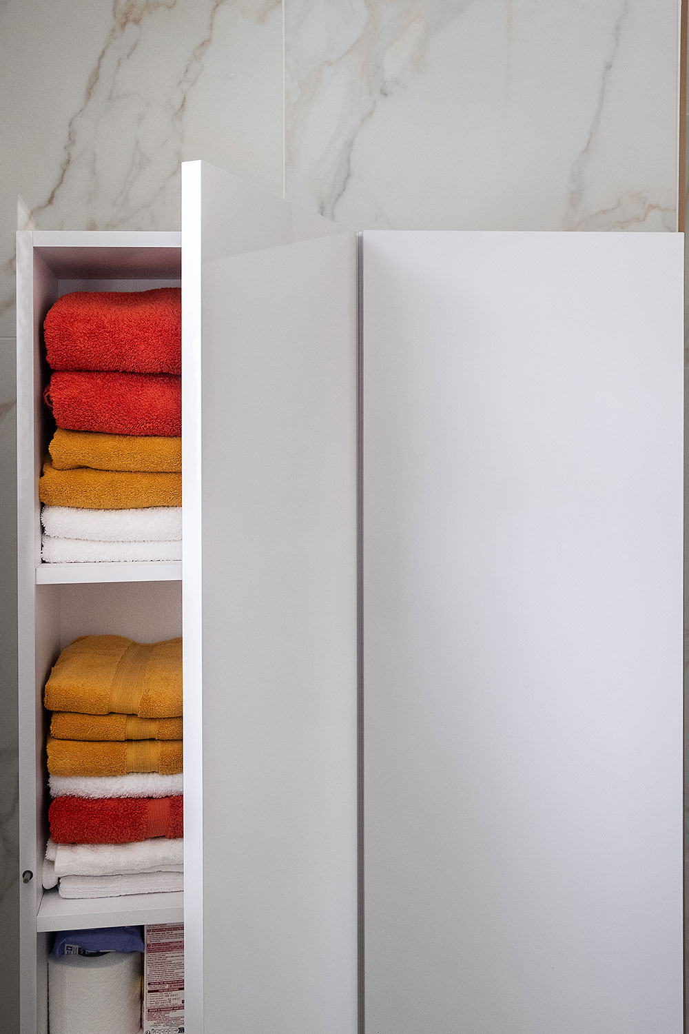 A tall cabinet open to reveal the customer's neatly arranged towels.